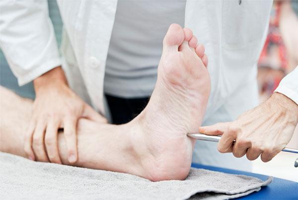 Lekarz badający stopę klienta